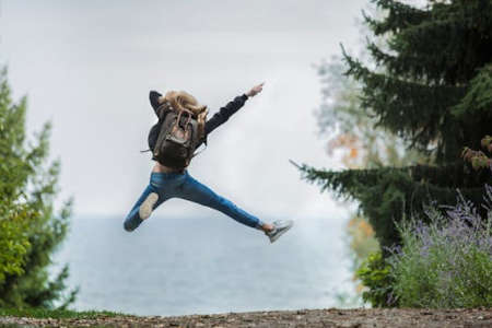 Photo of a person leaping for joy in a forest.